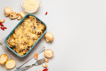 Baking dish with tasty rice casserole on light background