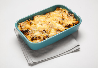 Baking dish with tasty rice casserole on light background