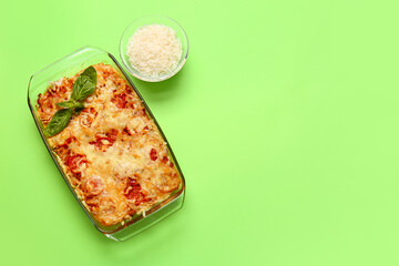 Baking dish with tasty rice casserole on color background