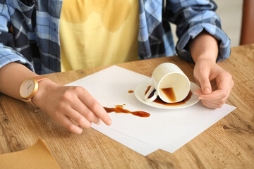 Woman with coffee stains on her t-shirt and spilled coffee in kitchen