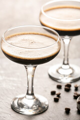 Two glasses of tasty espresso martini cocktail on table