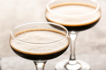 Two glasses of tasty espresso martini cocktail on table