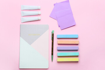 Composition with colorful chalks and notebook on color background