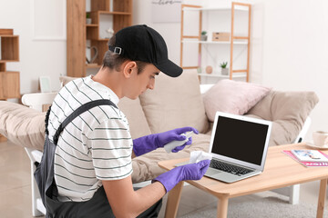 Worker cleaning laptop at home