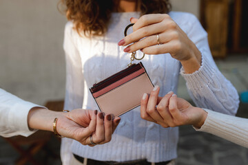 Close up unrecognizable women hands clutching a money bag purse. lending beauty accessories concept.