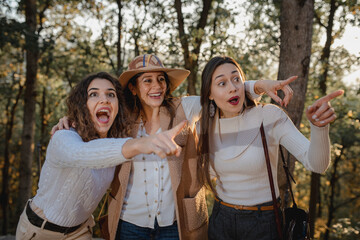 Three beautiful caucasian women portrait. Ladies walking with happy cheerful faces pointing something. Sisters and friends spending time together.