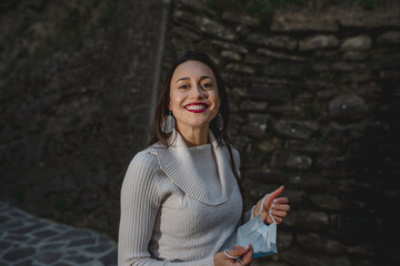 Young smiling woman portrait. Happy, carefree, playful girl holding face mask. fashion, style, Cold season and positive concept.