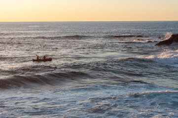 
people doing sports in canoe at sunset in the sea