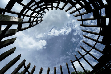 Looking up into the sky in a circular wooden grid structure
