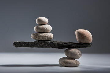 Balancing pyramid of sea pebbles on a gray background, the concept of harmony and balance, heavy...