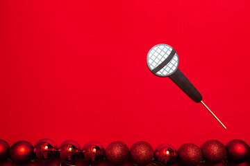 A red color banner with microphone on a stick. A props for entertaining guests at a New Year...