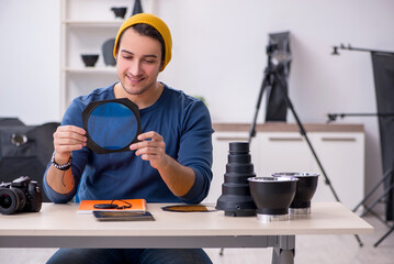 Young male photographer working in the studio