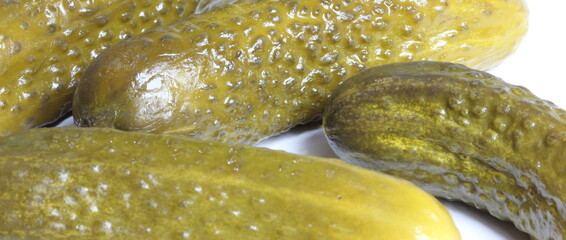 several pickled green pickles in a glass