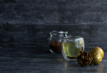 Buckwheat (buckwheat) tea in a transparent glass and tea leaves in a jar on a dark background. A useful alternative to other drinks.