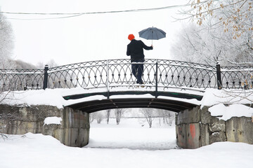 Winter walk with an umbrella.Man in a coat with an umbrella, walk against the backdrop of the winter landscape, winter view