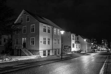 Leere Strassen und hell erleuchtete Fenster in Reykjavik. Die sonst belebte Innenstand ist wegen der Corona-Maßnahmen und ausbleibenden Tourisen wie leer gefegt. - obrazy, fototapety, plakaty