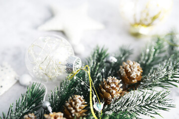 Evergreen tree handmade toys, snowflakes, globes and fir branch on stone background, Xmas greeting card with space for text wish