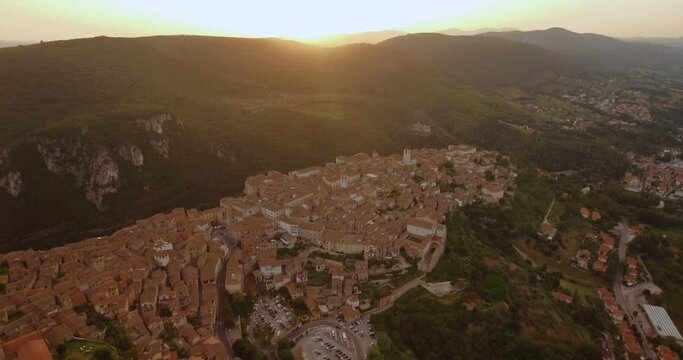 Aerial view of the cityscape of the Narni village, colorful sunset, in Umbria, Italy - reverse, pan, drone shot