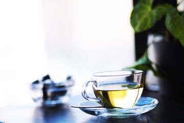 Hot steaming green tea in a cup on a rustic background