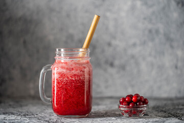 Cranberry and cowberry smoothie in mason jar with bamboo straw. Refreshing summer fruit drink. The concept of healthy eating. Copy space