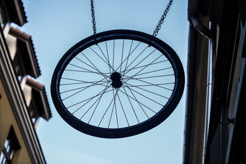 one, alone Bicycle wheel rim on iron chain against blue sky background.