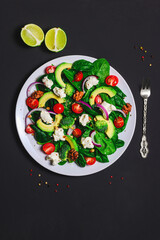 Healthy food concept: salad with avocado, broccoli, spinach, cream cheese, cherry tomatoes and walnuts
