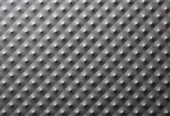 close-up of a dark gray metal plate with bulges, pimples. Background for a business card on the theme of electronics, cars, wrapping, gift wrapping paper
