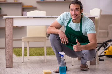 Young male contractor cleaning the house