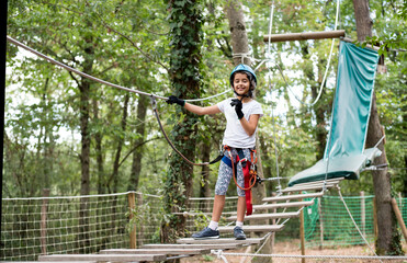 The girl in the adventure park. Obstacle course in the forest.