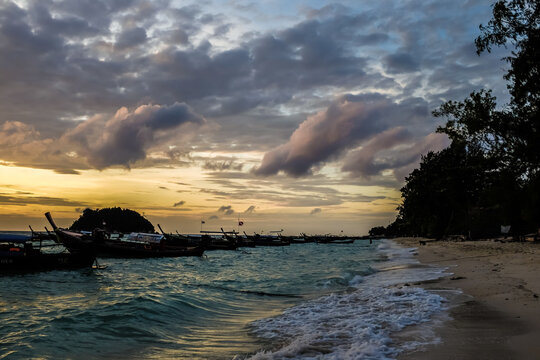 Sea beach sunset sea wave with boat against colorful sky cloud