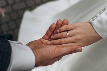 bride and groom holding hands with rings