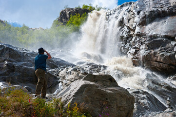 The photographer takes pictures of the Alibek waterfall.