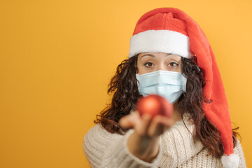 young girl prepares for christmas with coronavirus mask