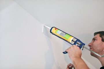 Handyman using silicone sealant adhesive bond for fixing household things.