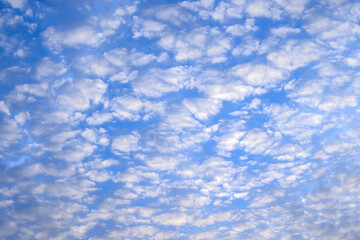 Bright sky illuminated by pink sunset light as background and texture.