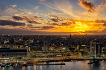 View on the historic city center of Amsterdam with the central train station and river IJ during sunset 