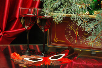 Vintage clock, glass of champagne, burning candle and Christmas decorations.