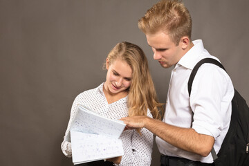 Two students young man and woman watching papers