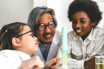 Group of teenage students learning with teacher and doing a chemical experiment and holding test tube in hands in the experiment laboratory class on table at school.Education concept