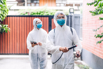 Fototapeta na wymiar Professional teams for disinfection worker in protective mask and white suit disinfectant spray cleaning virus for help service kill coronavirus at customer home