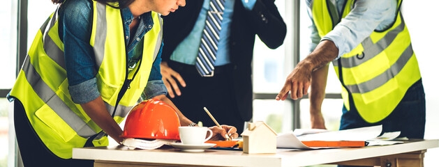 Professional of team engineers cargo foreman in helmets working with blueprint and construction...