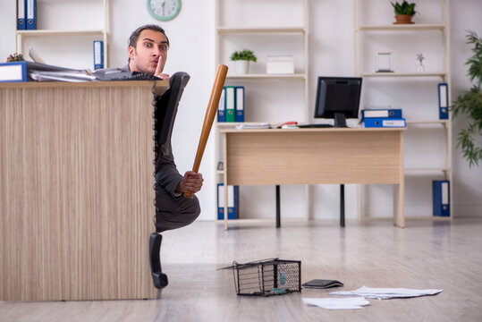 Young male employee and mousetrap in the office
