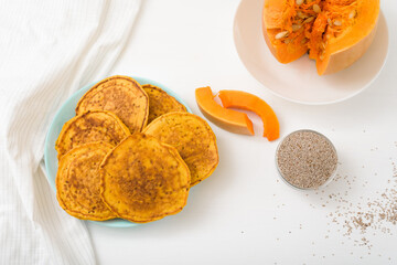 a stack of autumn pumpkin pancakes with Chia seeds and honey on a light background. delicious healthy vegetarian diet Breakfast. the concept of taking care of your body, the keto diet