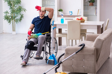 Young leg injured contractor in wheel-chair cleaning the house