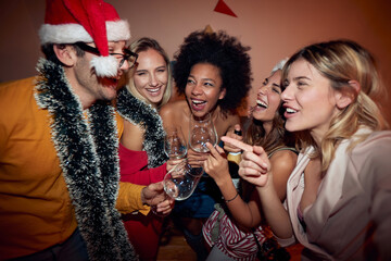 group of female friends at new year party with one male friend, laughing