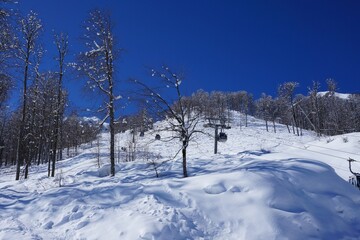 Beautiful winter landscape in the mountainous area, ski slopes, cable car.