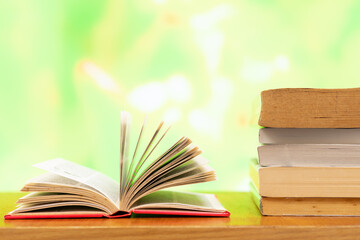A pile of books and open book with blurred colour as background and copy space