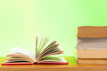 A pile of books and open book with blurred colour as background and copy space