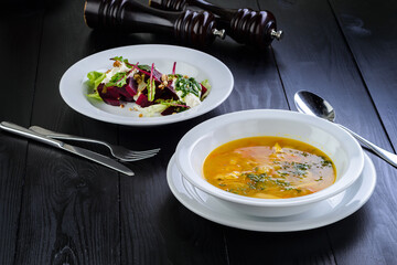Summer lunch green salad chicken soup, served on wooden table, two course meal business lunch at the restaurant