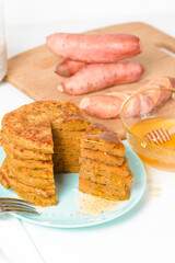 homemade autumn stack vegetarian pancakes with sweet potatoes and Chia seeds, low-calorie Breakfast, taking care of the body. watered with honey on a light background. sliced pancakes